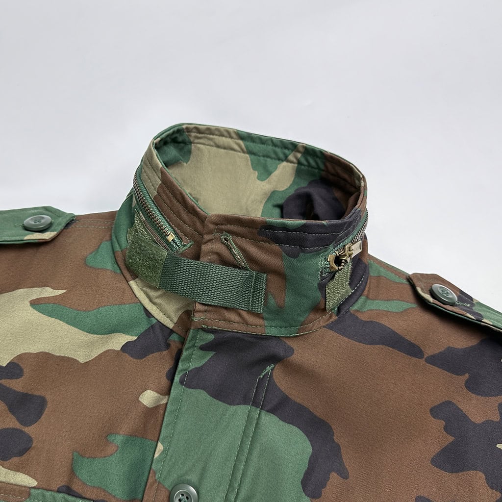 Close-up of the reinforced collar on the Woodland Camo Tactical Jacket, featuring velcro and button closures for security and comfort.
