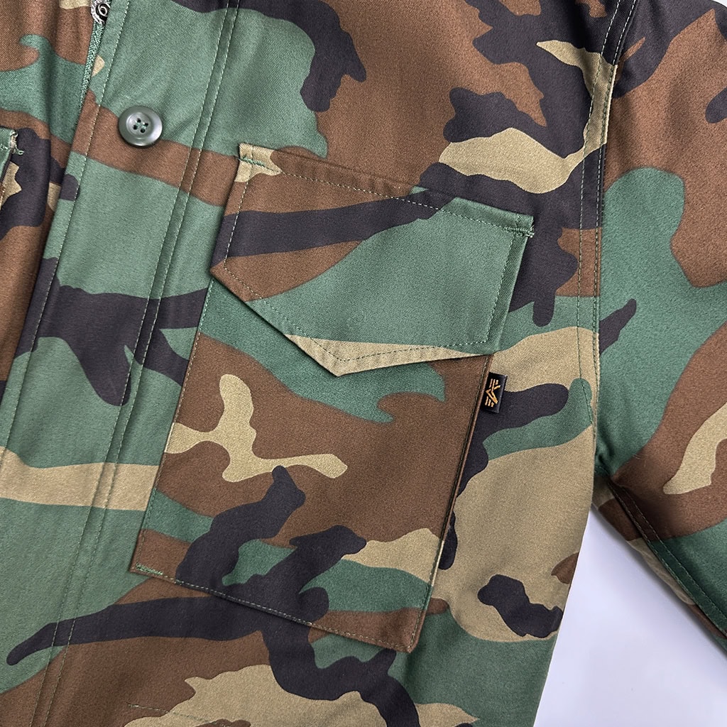 Detail of the large, expandable breast pocket on the Woodland Camo Tactical Jacket, designed for secure storage of essential gear.