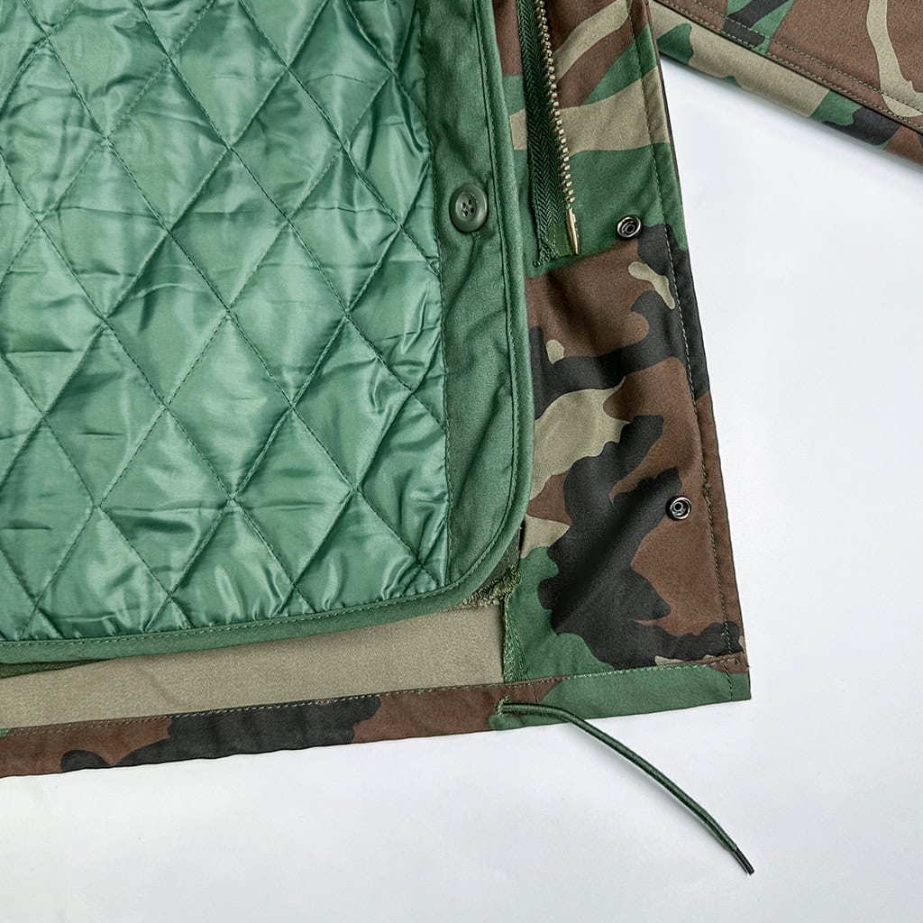 View of the optional quilted liner for the Woodland Camo Tactical Jacket, providing extra insulation for cold weather operations.