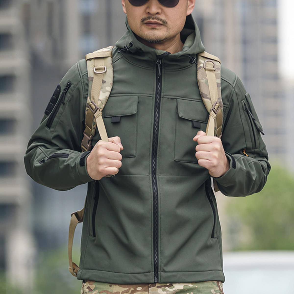Man wearing the olive green Onken Beetle fleece lined tactical jacket, showcasing its professional profile for security details and outdoor missions.
