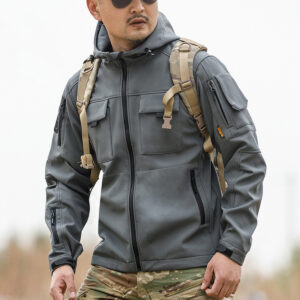 Operator wearing the grey Hooded Tactical Softshell Jacket, showcasing its athletic fit and compatibility with gear for military and security use.