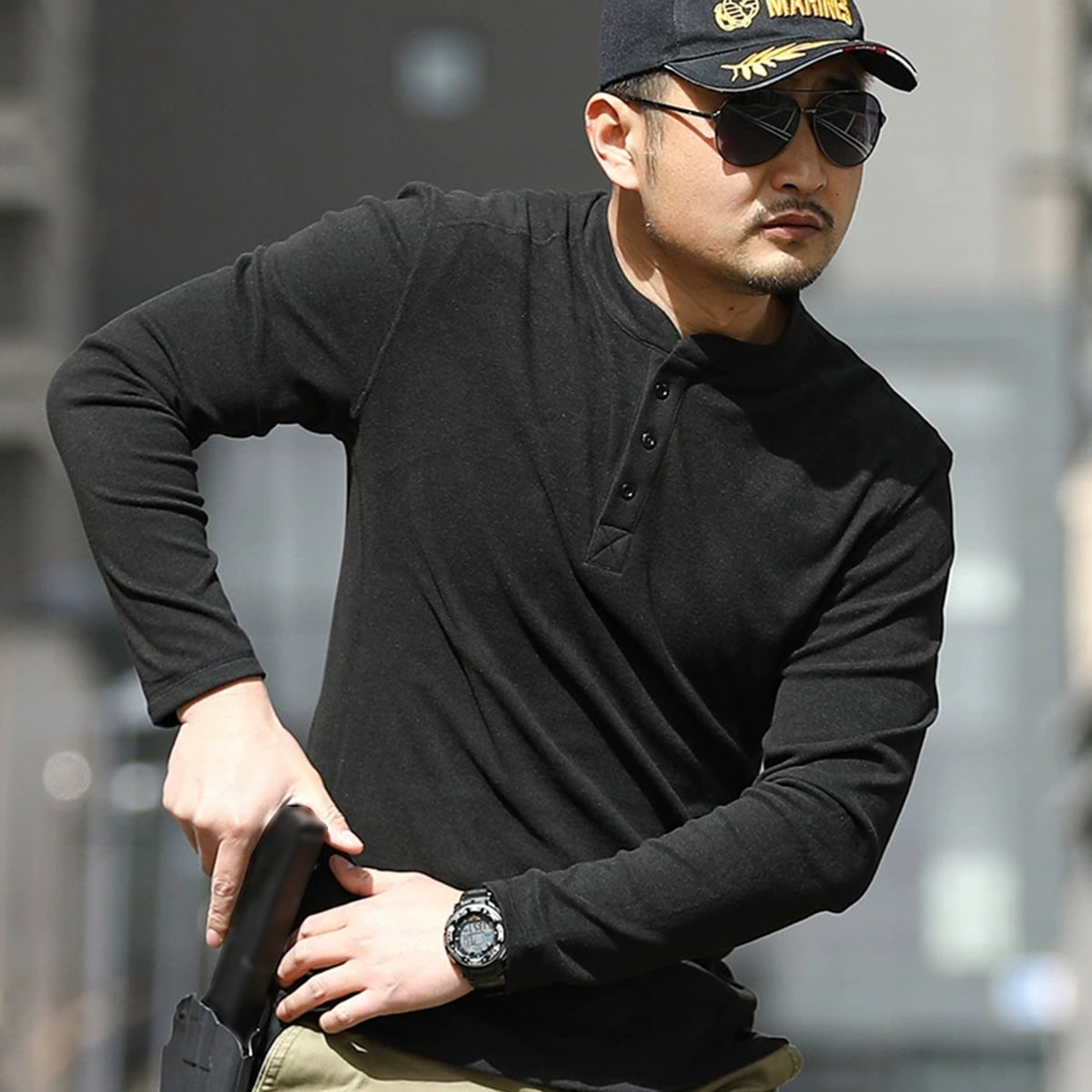 A professional wearing the black Warhorse performance tactical henley, demonstrating its athletic fit and suitability for plainclothes or covert duty.