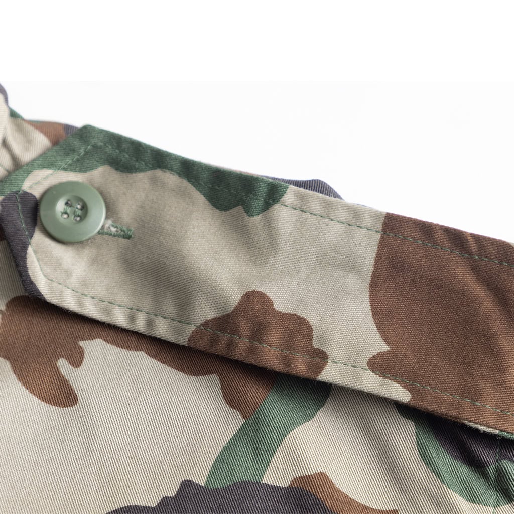 Close-up of the button-flapped bellowed breast pocket on the Woodland Camo BDU jacket, providing secure storage for essential gear.