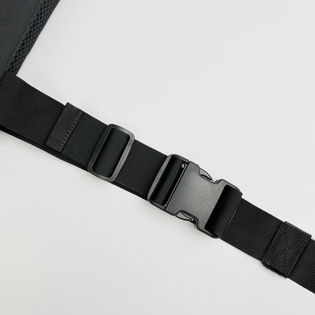 Close-up of the quick-release buckle on the waist strap of the Agile 6094 lightweight plate carrier, for rapid donning and doffing.
