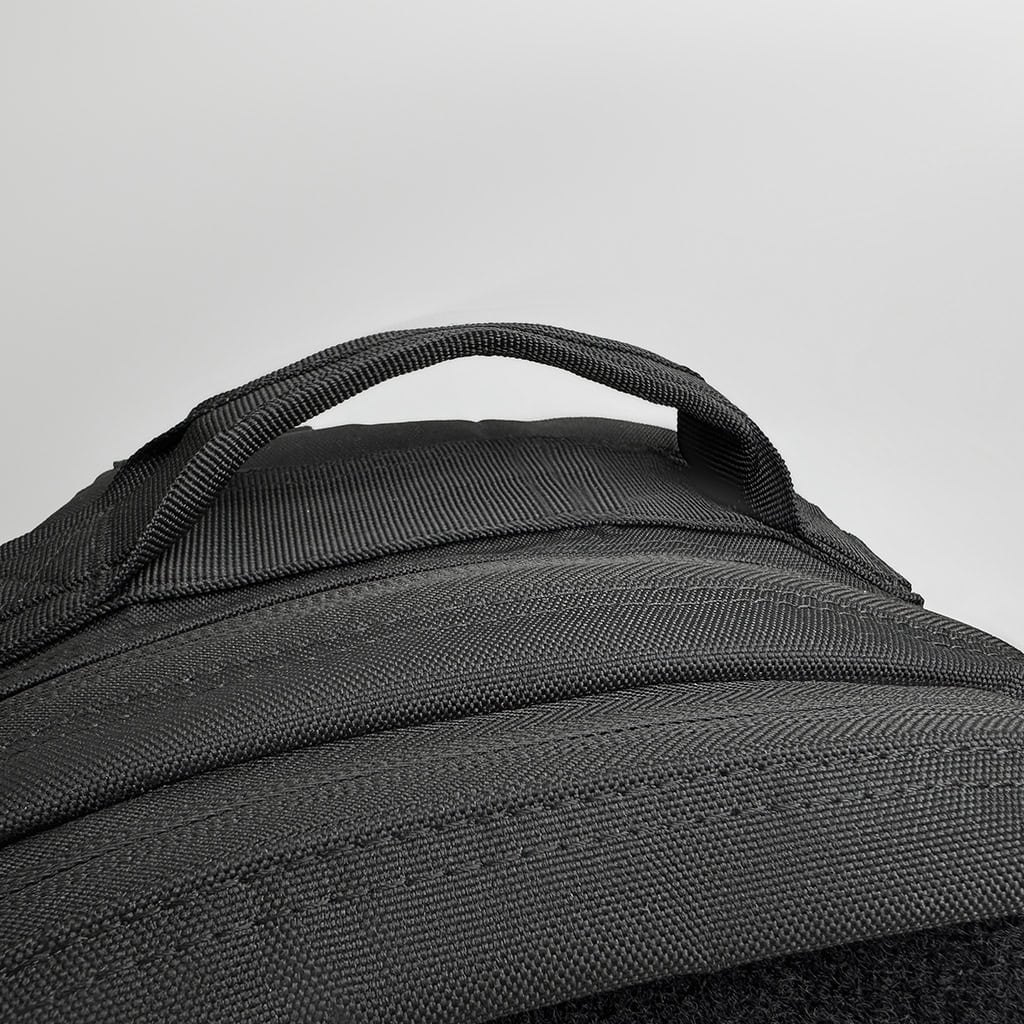 Detail of the "Ghost" backpack's sturdy, reinforced grab handle, engineered for heavy loads and professional use.