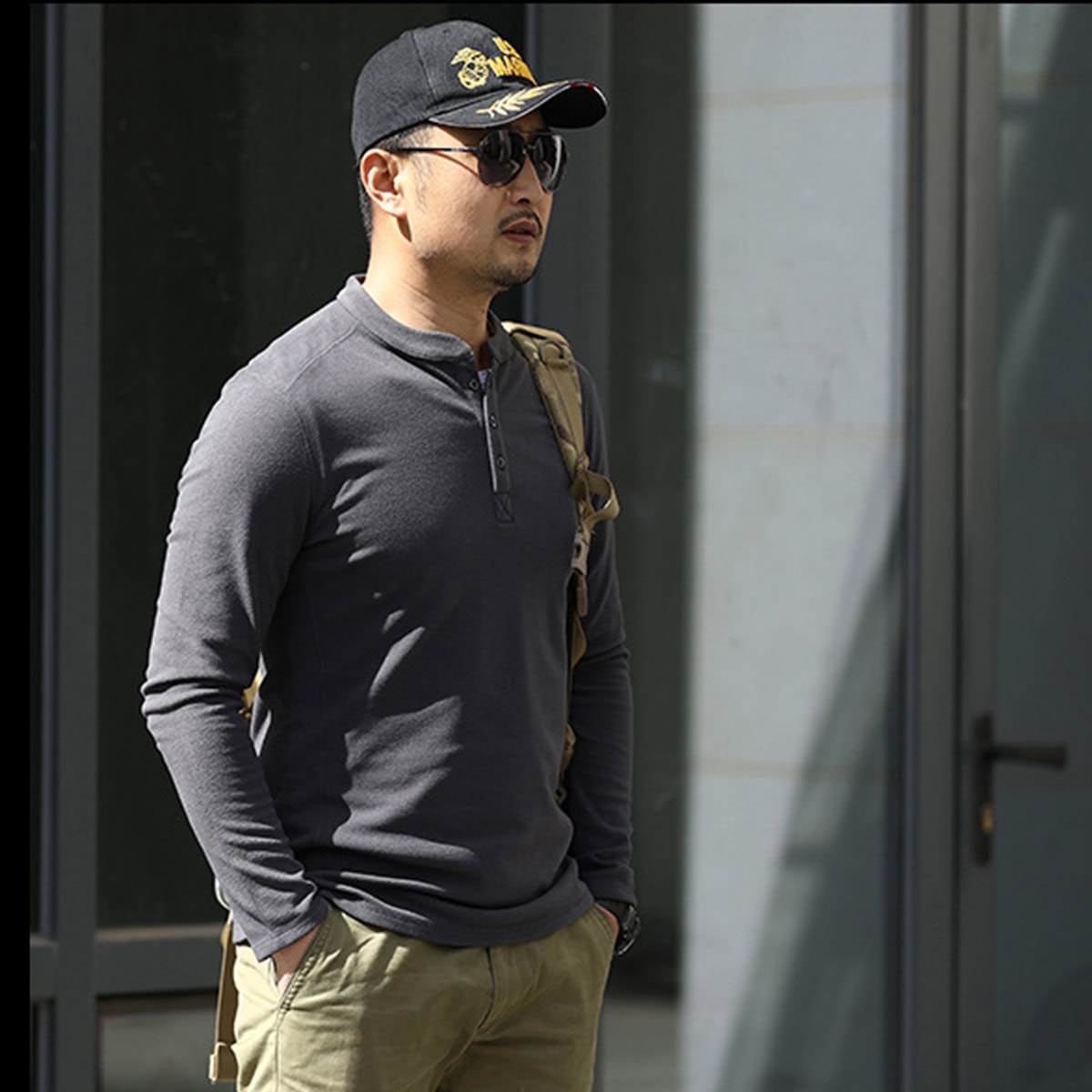 Operator wearing the grey Warhorse performance tactical henley, showcasing its compatibility with backpacks and other field gear.