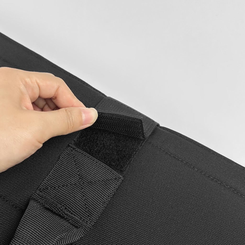 Close-up of the rapid-release velcro tab on the ballistic briefcase, the mechanism for its instant, one-handed deployment.