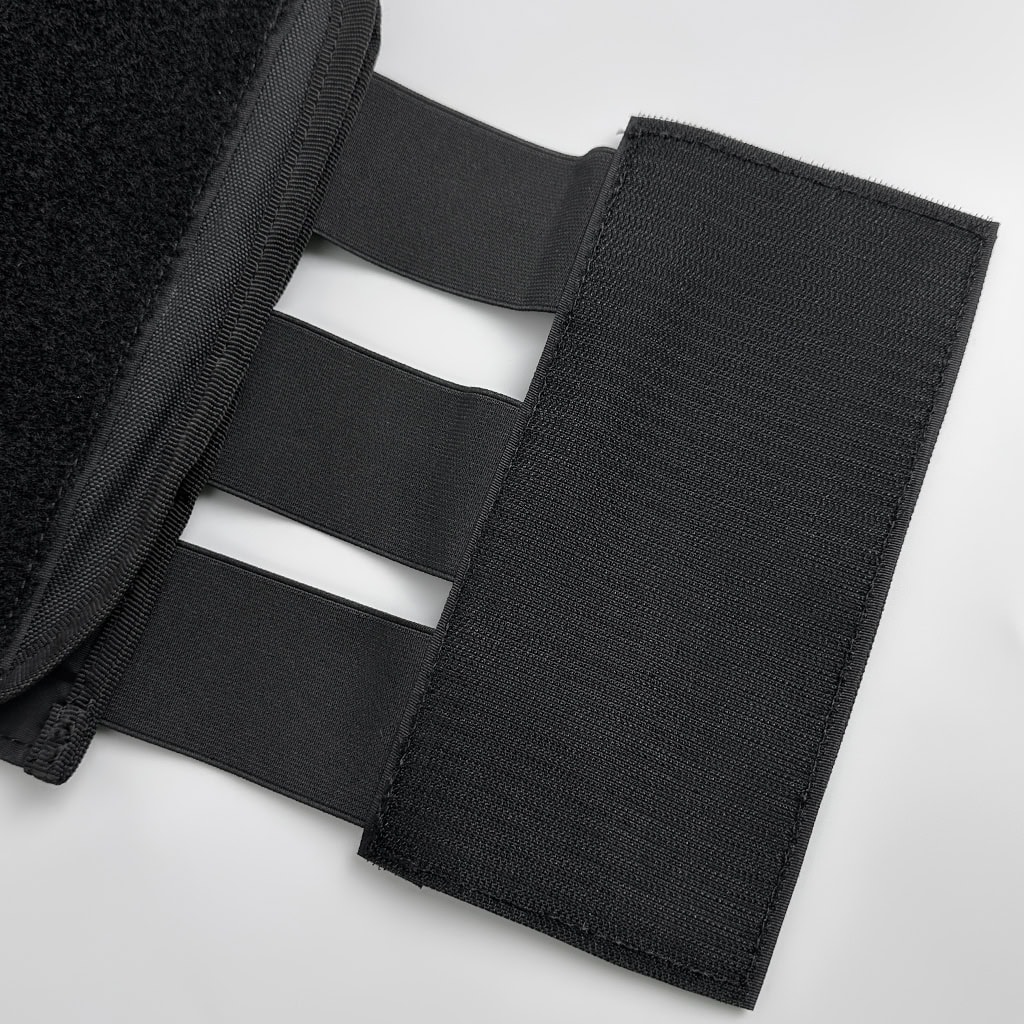 Close-up of the adjustable waist velcro cummerbund of the MOLLE plate carrier, which provides a secure and comfortable multi-point fit.