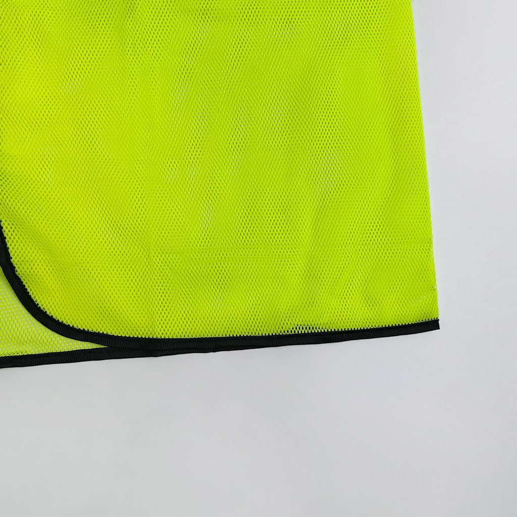 Close-up of the reinforced black trim on the hem of the ANSI Class 2 safety vest, which enhances durability and hides dirt.