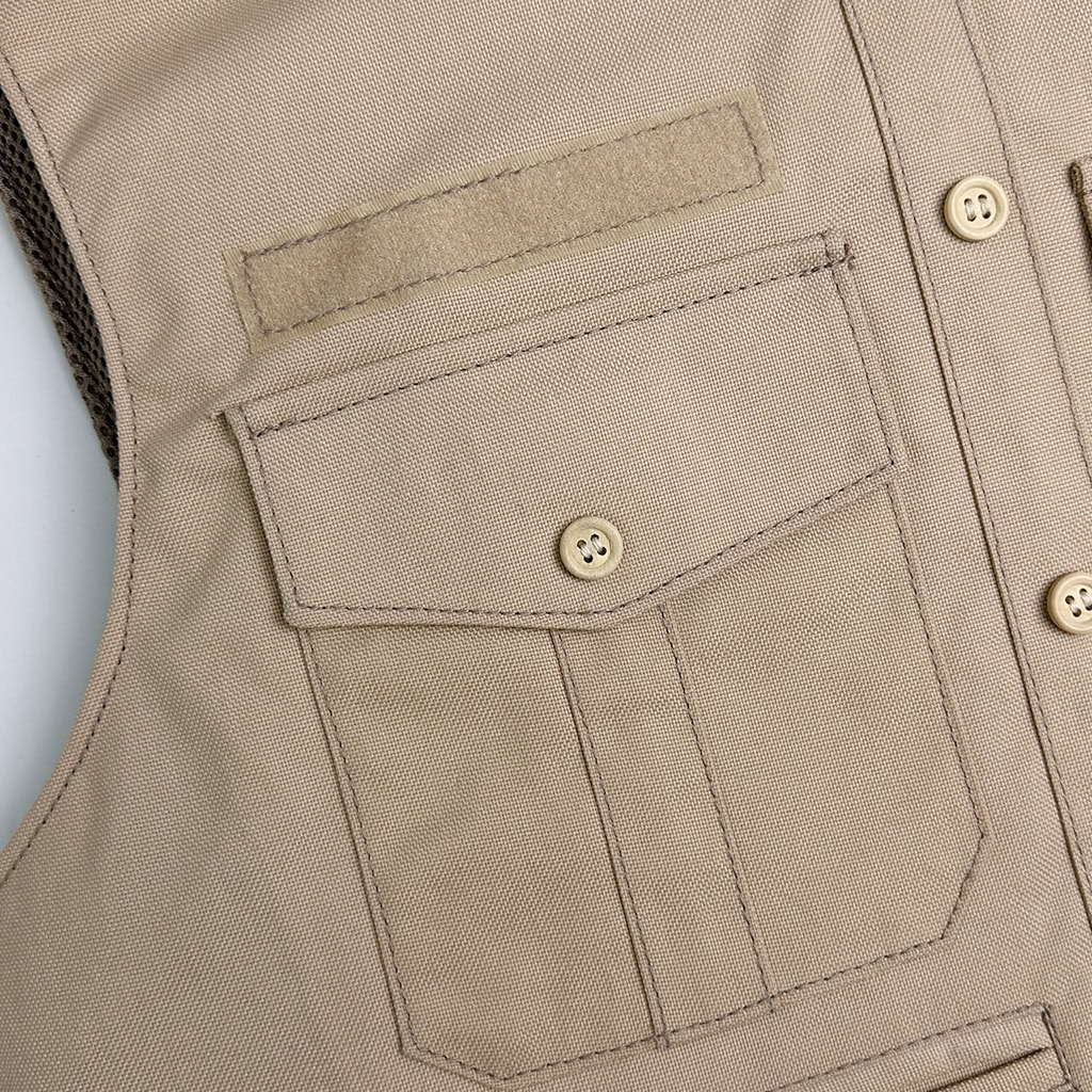 Close-up of the buttoned front utility pocket on the "Press" overt body armor vest, designed for storing notebooks, media cards, or equipment.