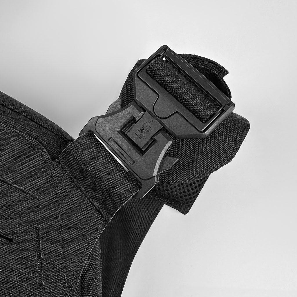 Close-up of the shoulder quick-release buckle on the Vanguard plate carrier, a critical safety feature for emergency doffing.