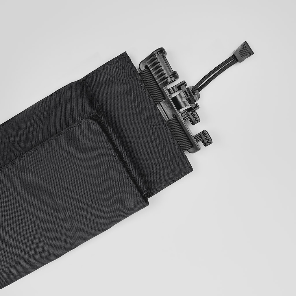 Close-up of the shoulder quick-release buckle on the "Spartan" plate carrier, a critical safety feature for emergency doffing.