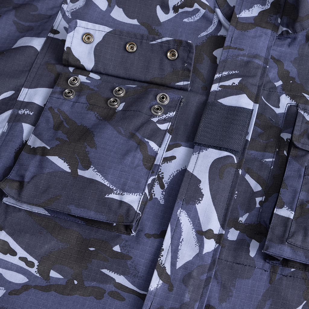 Close-up of the secure, multi-button waist pockets on the custom blue camo combat uniform jacket.