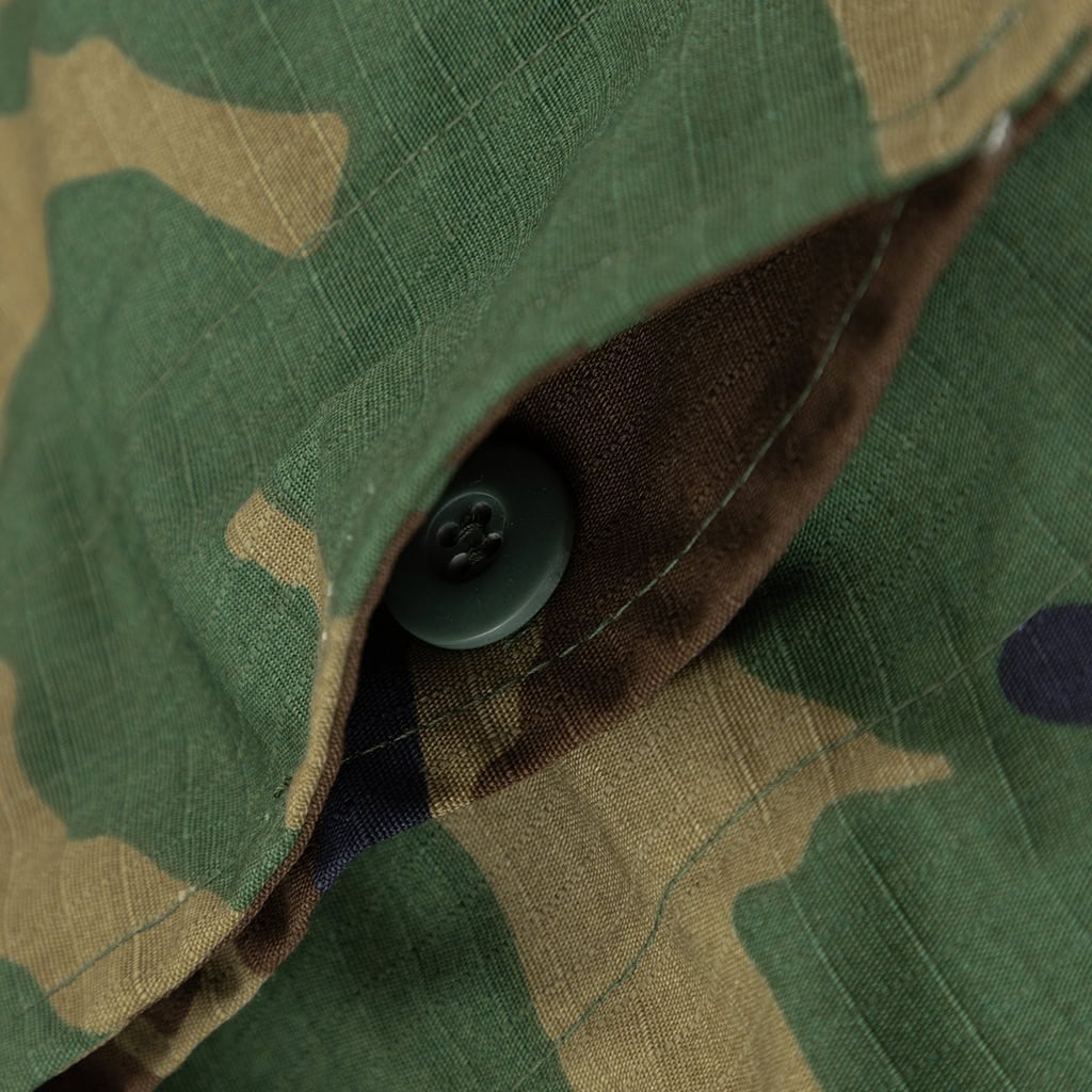 Close-up of a button on the pocket flap of the custom woodland camo BDU uniform jacket.