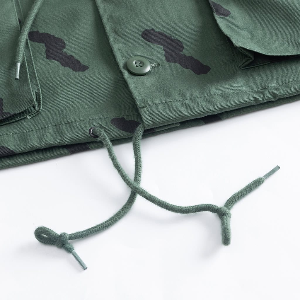 Detail of the adjustable drawstring waist on the custom Tanzanian green camo tactical field jacket.