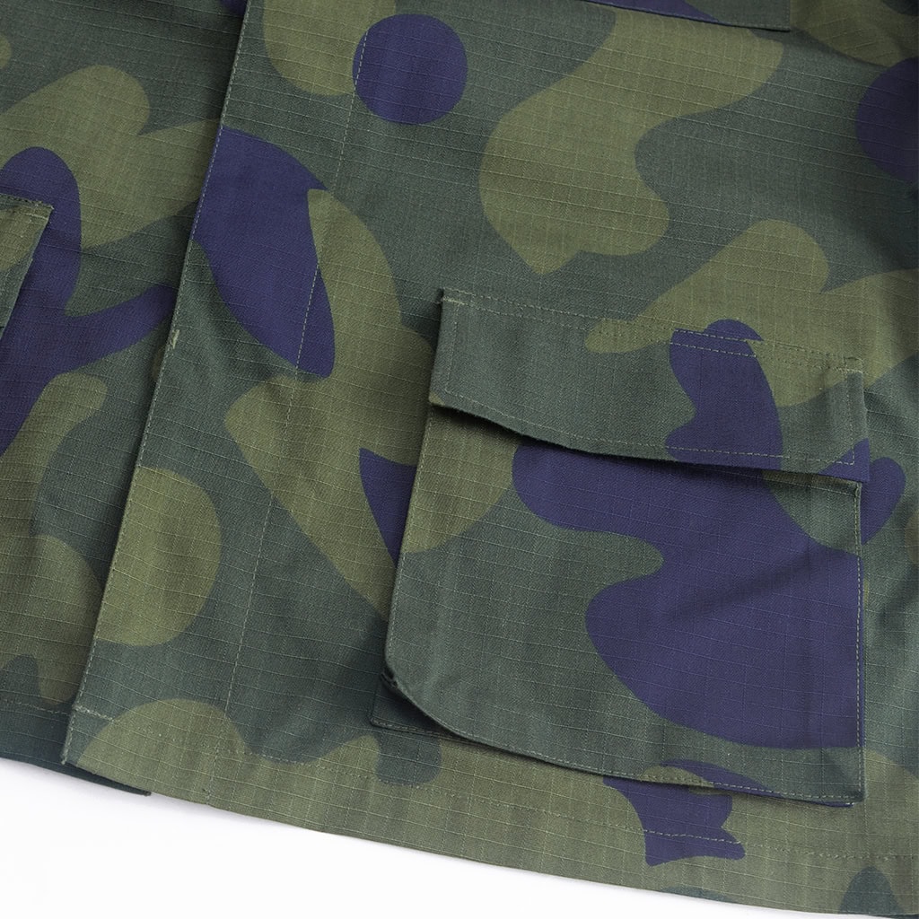 Close-up of a large waist pocket with button flap on the custom DRC green camo uniform jacket.