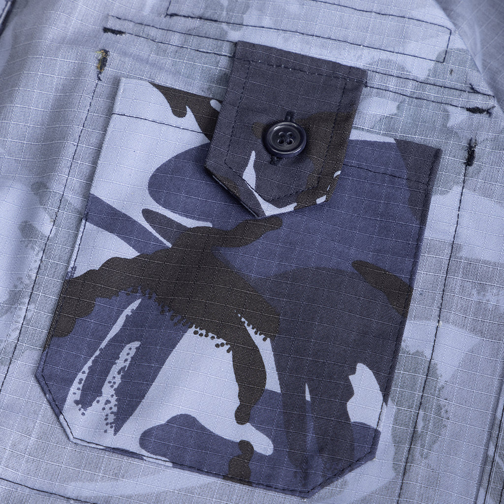 Close-up of the large, expandable side cargo pocket on the custom blue camo combat trousers.