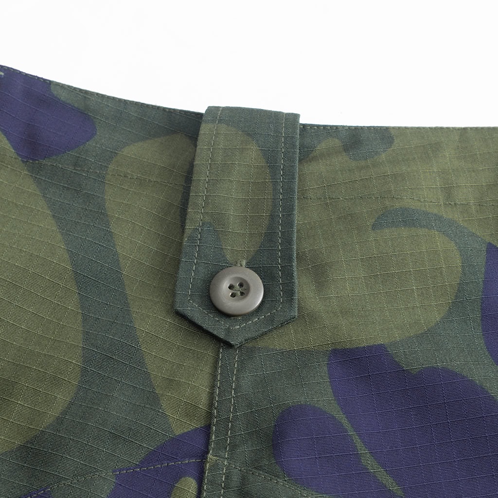 Close-up of the button on the belt loop of the custom DRC green camo combat trousers.