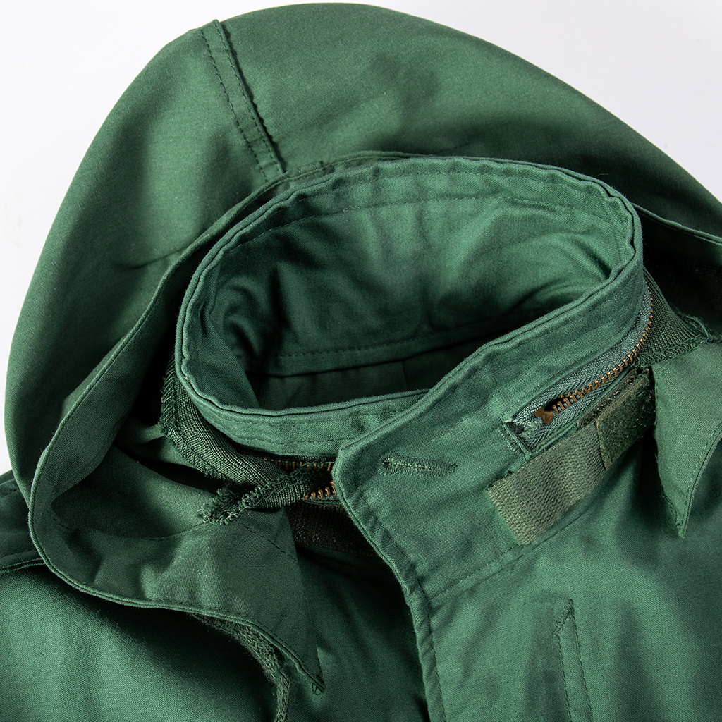 Close-up of the zippered collar compartment containing the stowable hood on the custom olive green M65 field jacket.