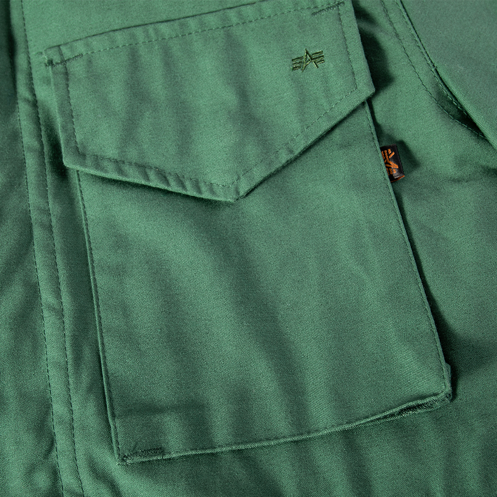 Close-up of a large, snap-closure breast pocket on the custom olive green M65 field jacket.
