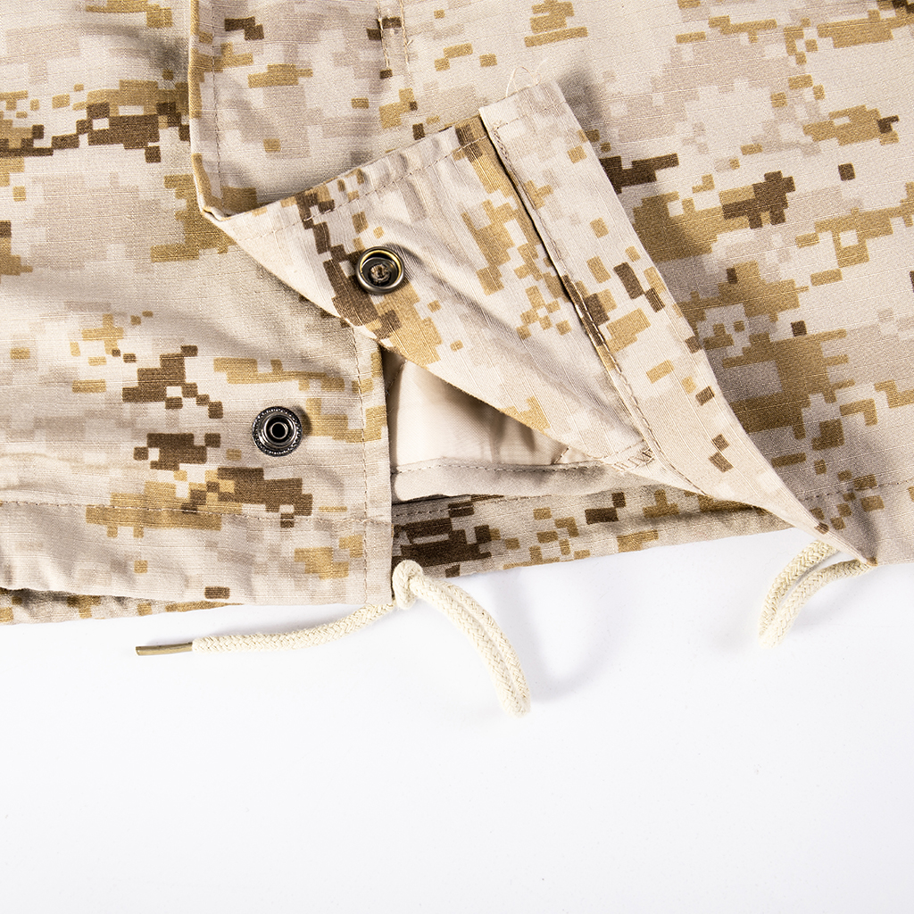 Close-up of the double-layer front closure with zipper and snap buttons on the custom digital desert M65 field jacket.