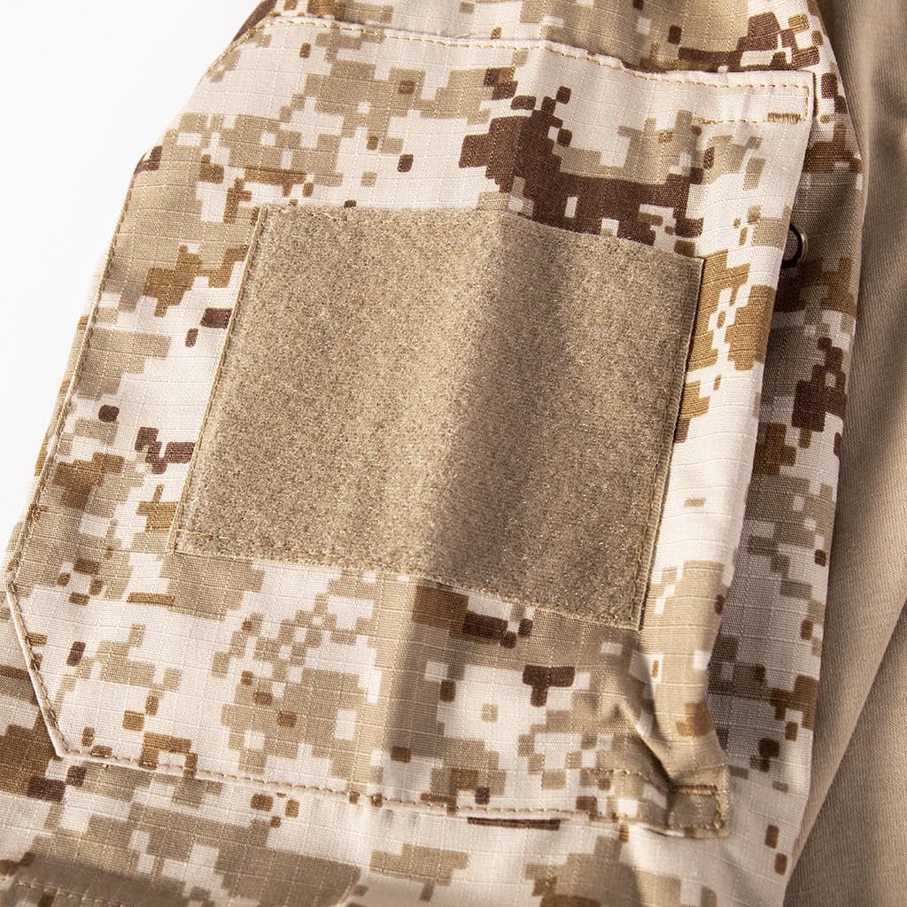 Close-up of the zippered arm pocket with a large velcro panel on the sleeve of the short sleeve desert digital combat shirt.