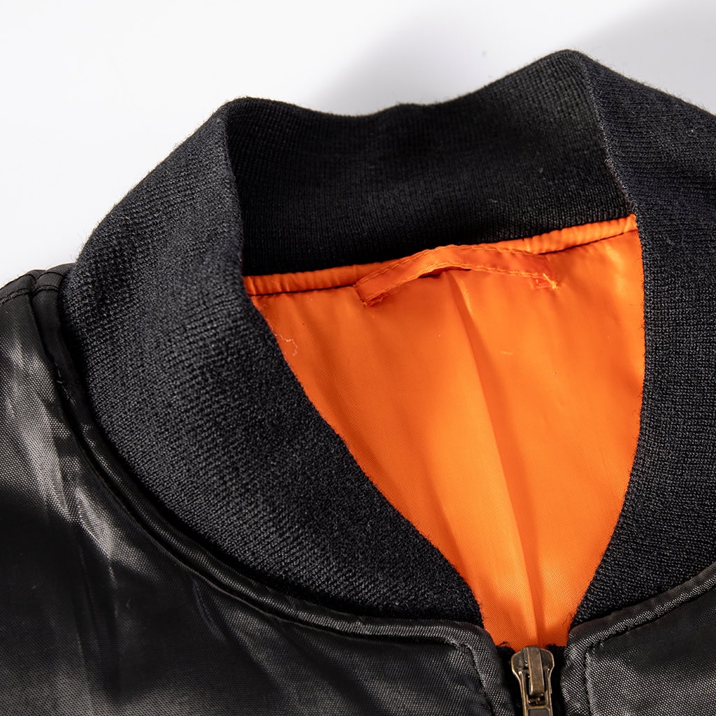 Close-up of the rib-knit collar and high-visibility safety orange lining on the custom black MA-1 flight jacket.