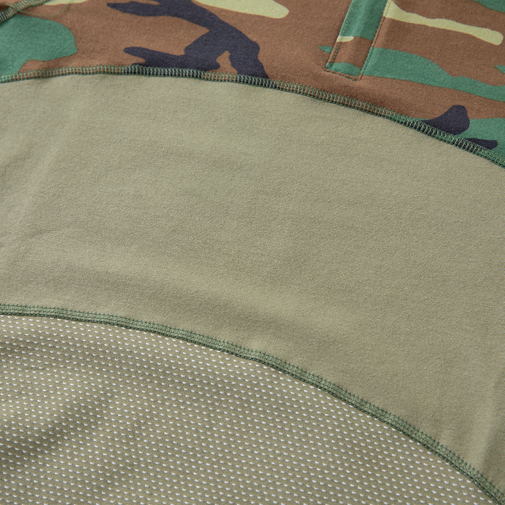 Detail of the highly breathable mesh fabric and reinforced seam on the lower torso of the custom woodland camo G4 short sleeve combat shirt.
