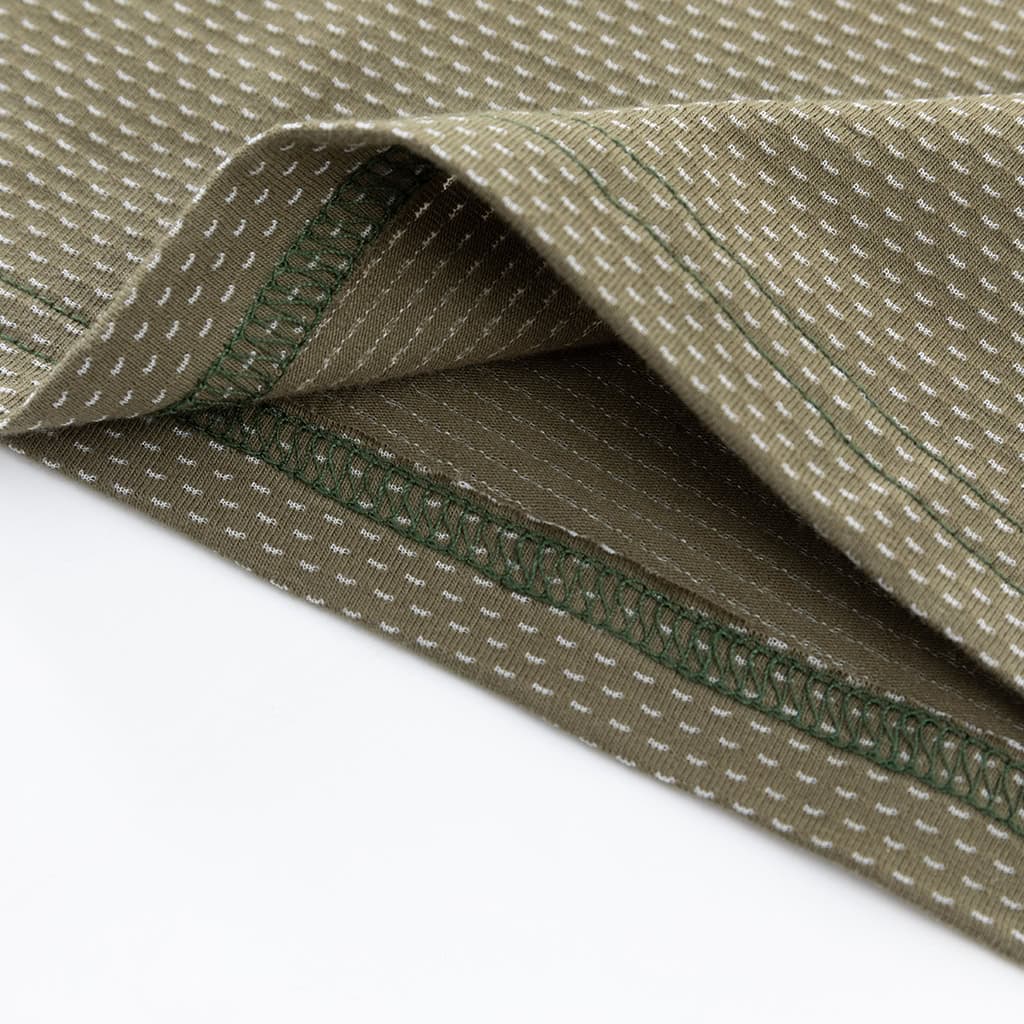 Close-up of the durable hem with locking process stitch on the custom woodland camo G4 long sleeve combat shirt.