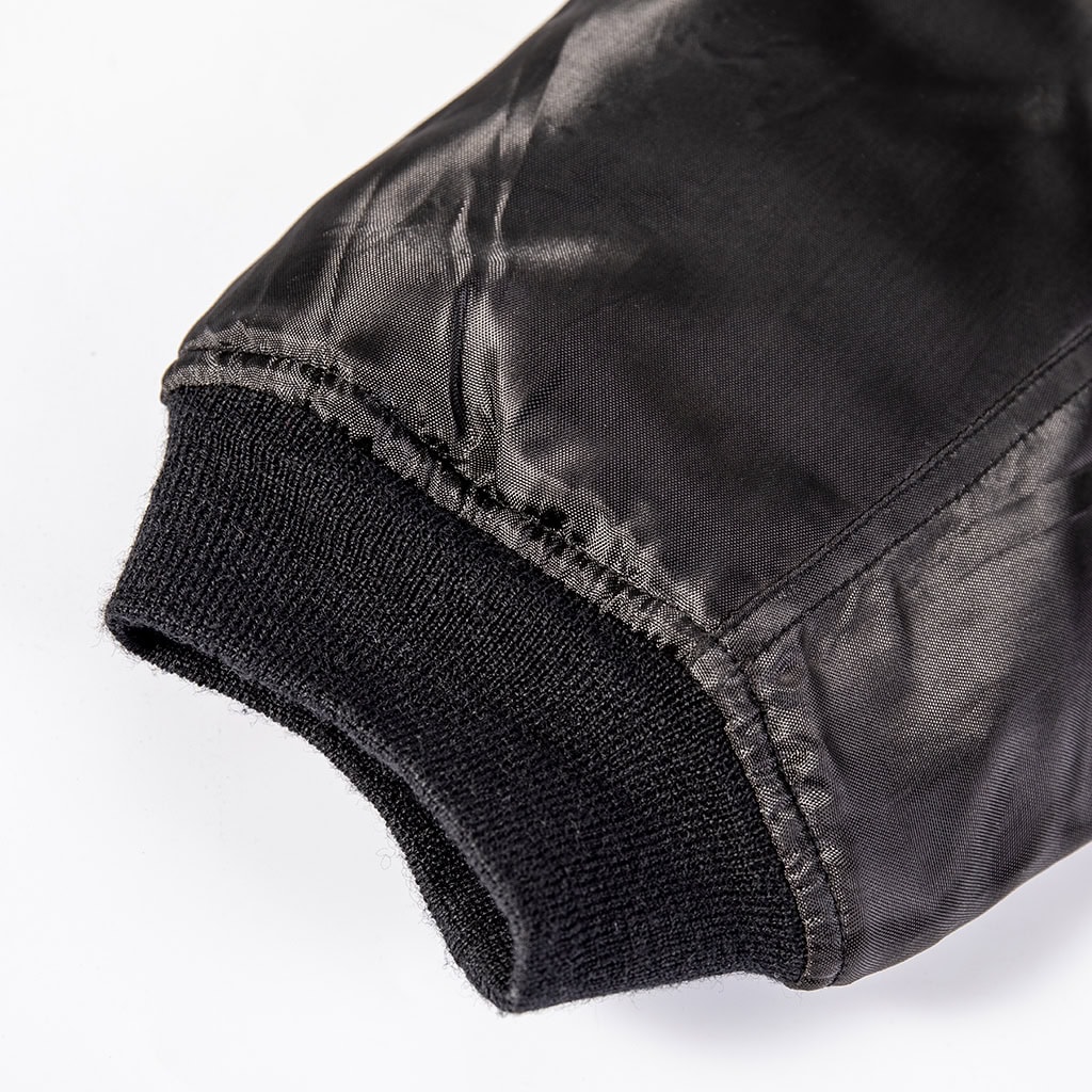Detail of the comfortable and secure rib-knit cuff on the sleeve of the custom black MA-1 flight jacket.
