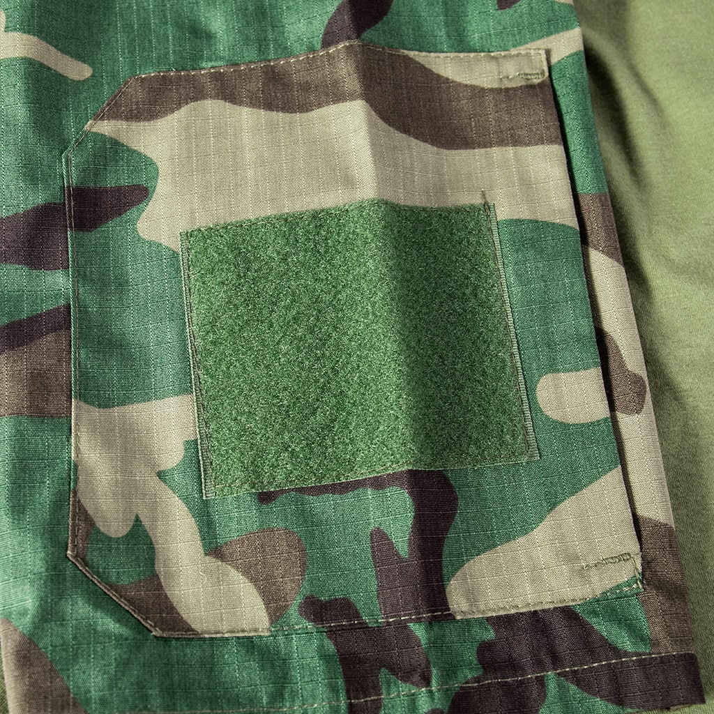 Close-up of the zippered arm pocket with a large velcro panel on the sleeve of the custom woodland camo short sleeve combat shirt.