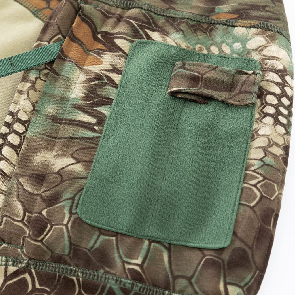 Close-up of the zippered arm pocket with velcro panels on the sleeve of the custom woodland python G4 long sleeve combat shirt.