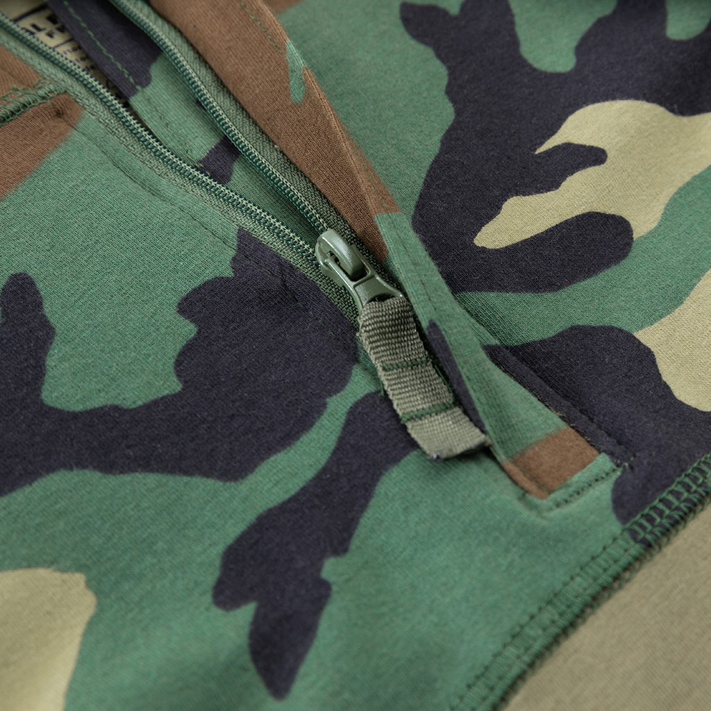 Detail of the premium zipper pull tab at the neckline of the custom woodland camo G4 long sleeve combat shirt.