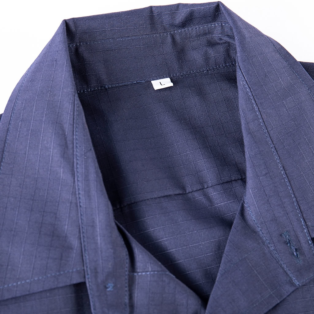 Close-up of the professional button-down collar on the custom navy blue ripstop security shirt.