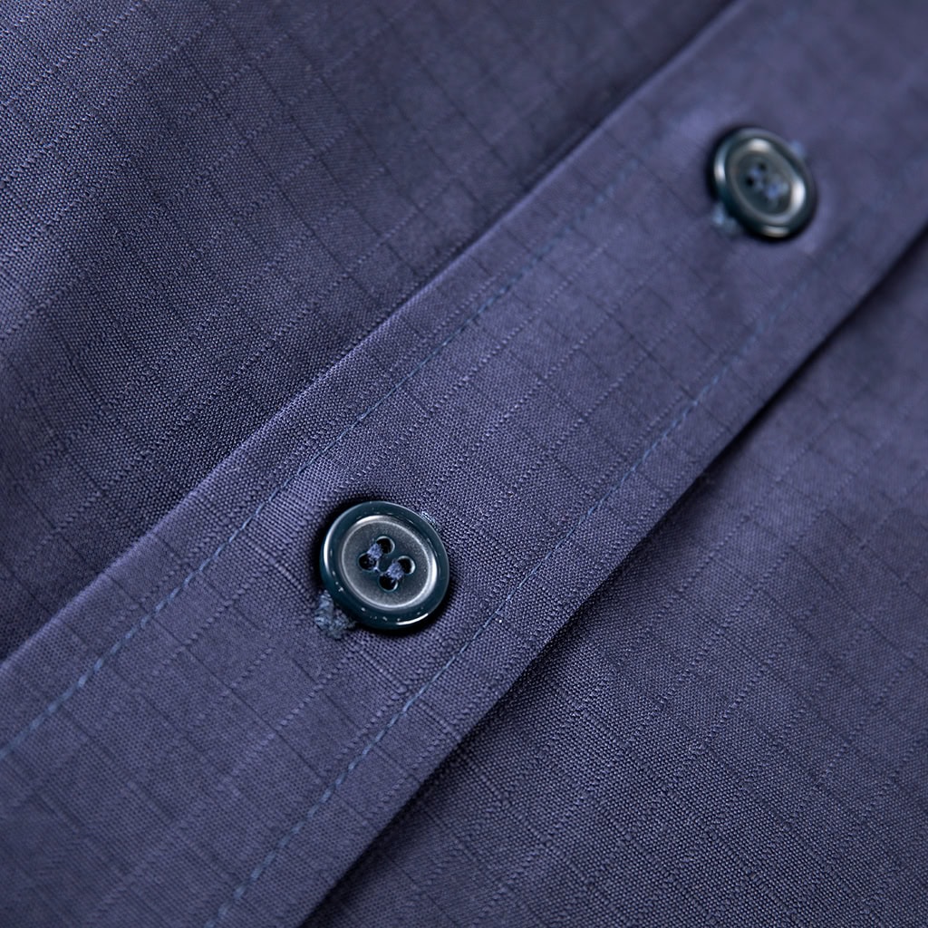 Close-up of the high-end custom buttons on the front placket of the custom navy blue ripstop security shirt.