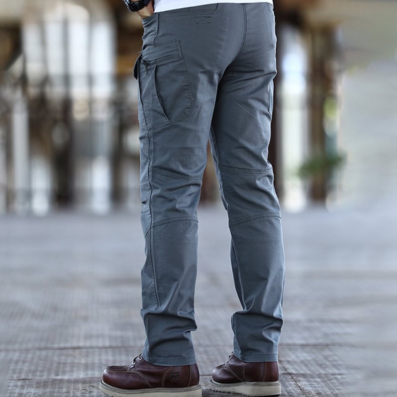 Back view of a man wearing the custom ripstop IX7 tactical pants in Grey Green, showcasing the rear pocket design.
