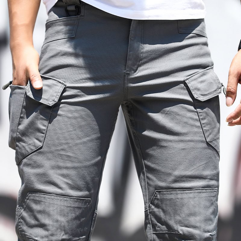Close-up of the front pocket area and articulated knees on a man wearing the Grey Green IX7 tactical pants.