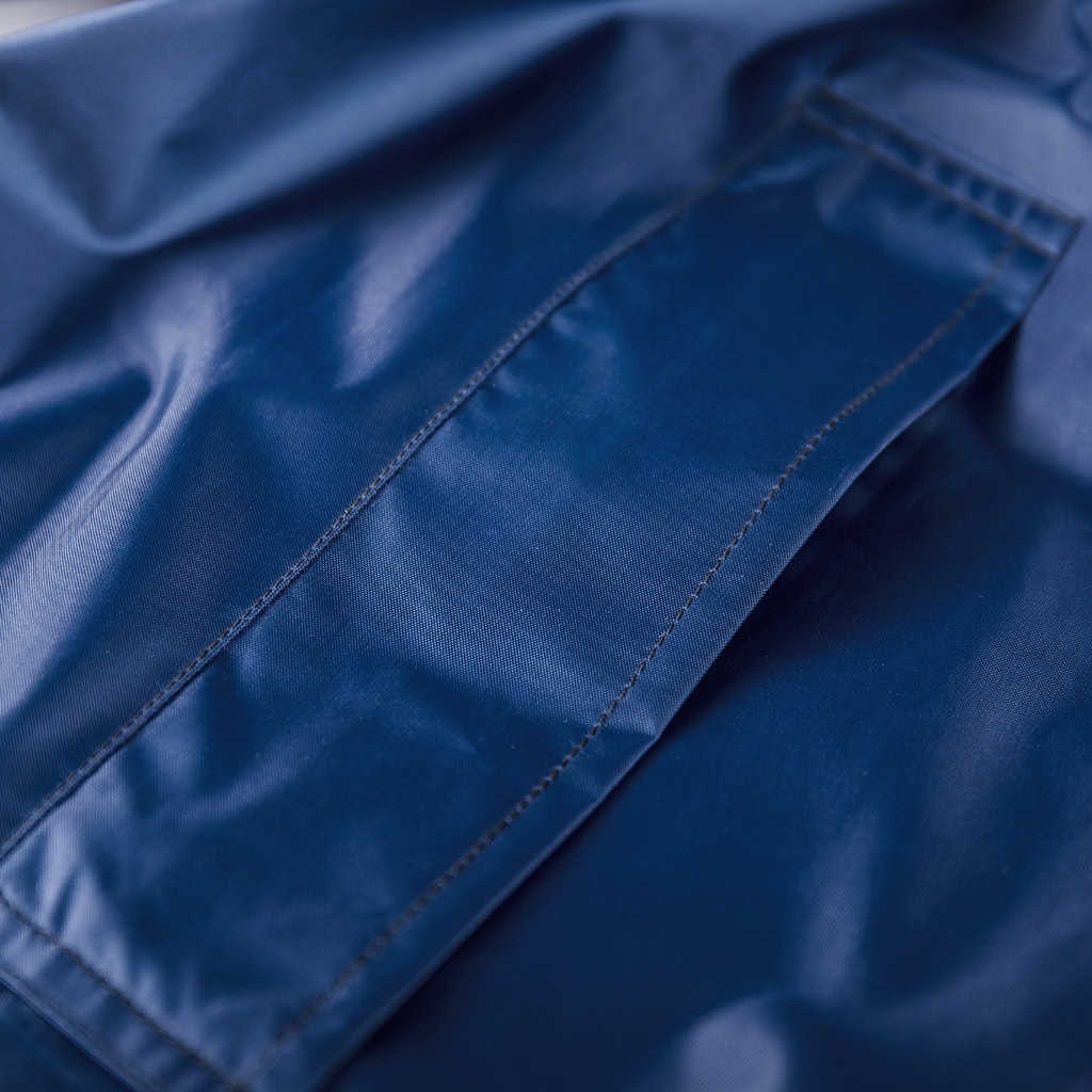 Close-up of the slanted side pocket on the custom navy blue waterproof long raincoat.