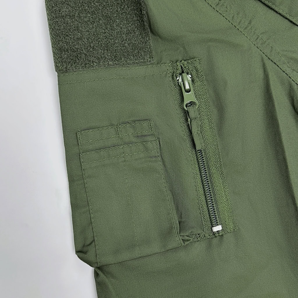Close-up of the zippered arm pocket with velcro panel on the sleeve of the custom olive green tactical shirt.