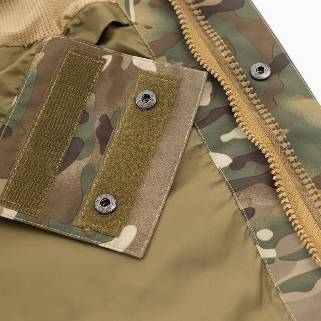 Detail of the double-layer front closure with zipper and snap buttons on the custom CP camo M65 style parka jacket.