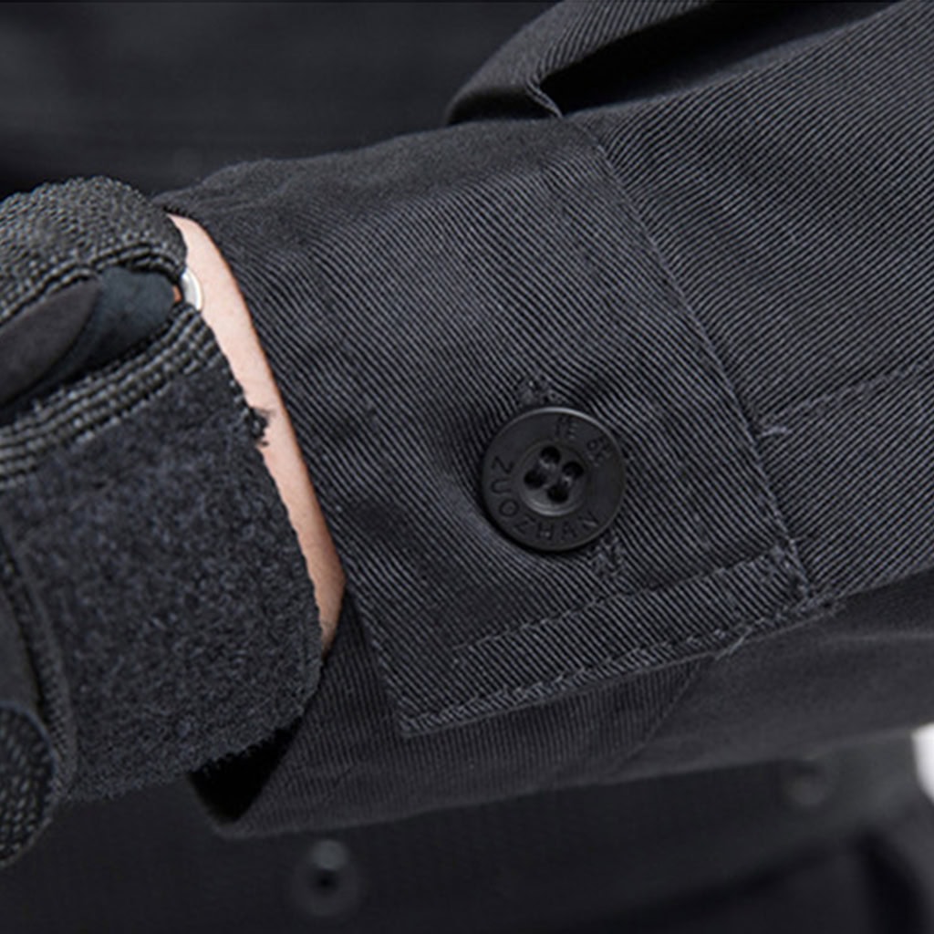 Detail of the adjustable button cuff on the sleeve of the custom black security guard uniform shirt.