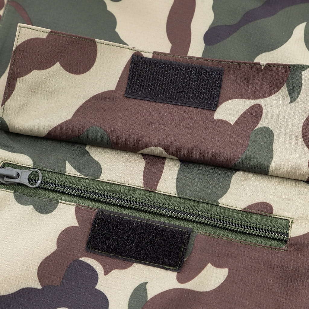 Detail of the zippered breast pocket with velcro panels on the custom woodland camo military rain poncho.