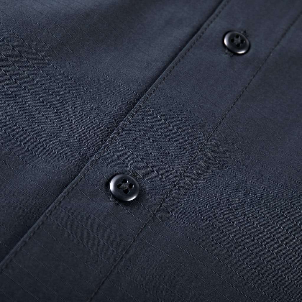 Detail of the high-end custom buttons on the front placket of the custom navy blue waterproof work shirt.