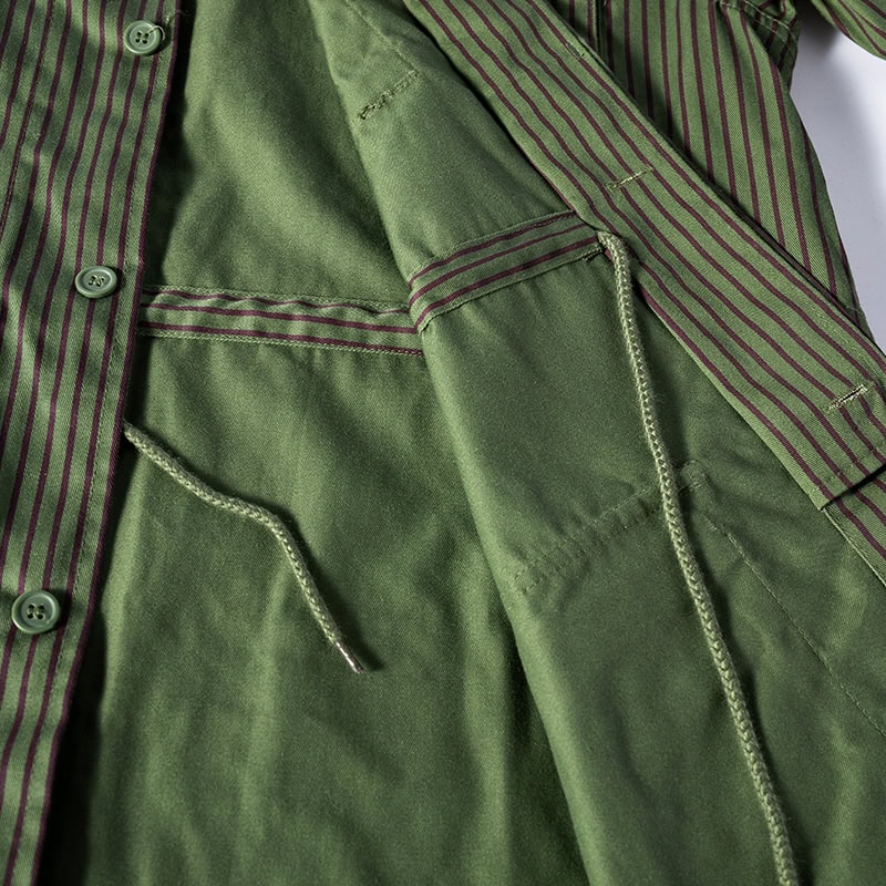 Interior view of the custom green striped security uniform jacket, showing the internal drawstring and construction.