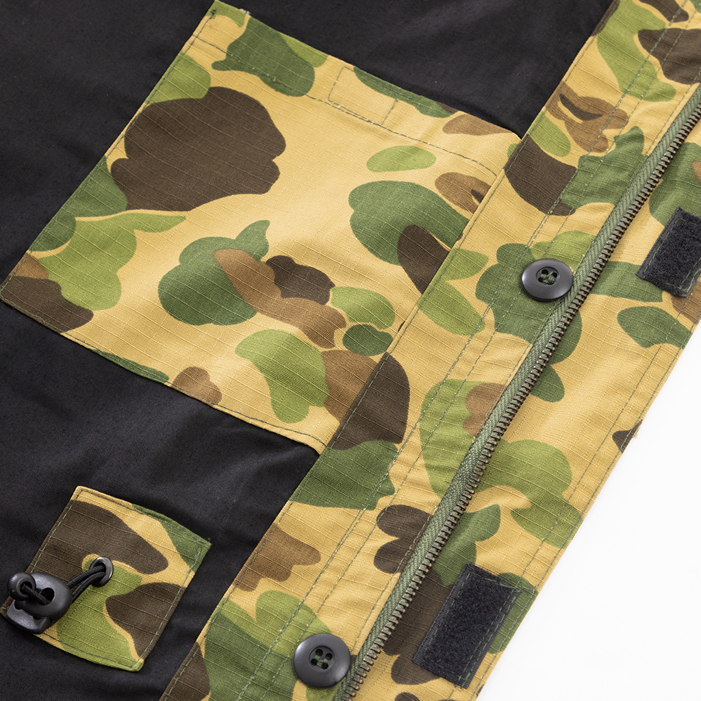 Close-up of the button-down breast pocket and shoulder epaulette on the custom duck hunter camo field jacket.