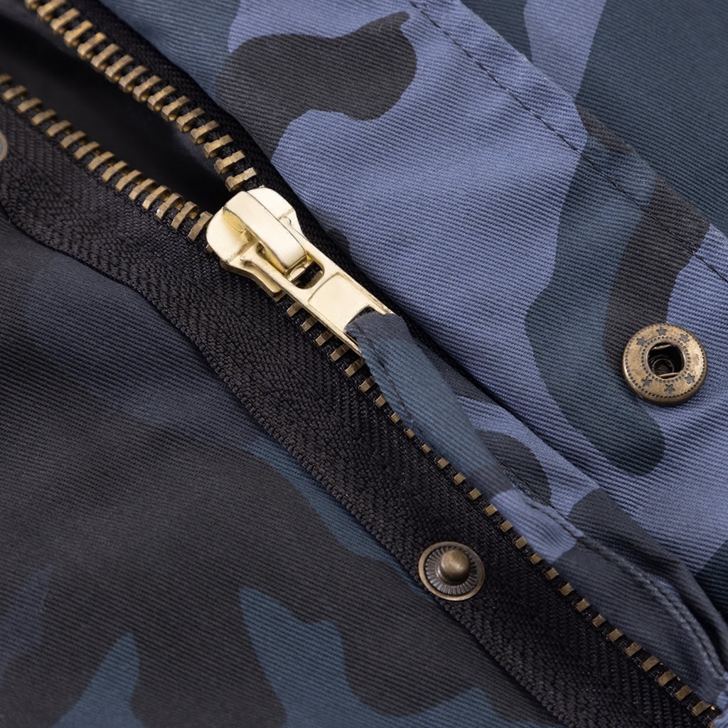 Close-up of the double-layer front closure with zipper and snap buttons on the custom midnight blue camo M65 jacket.