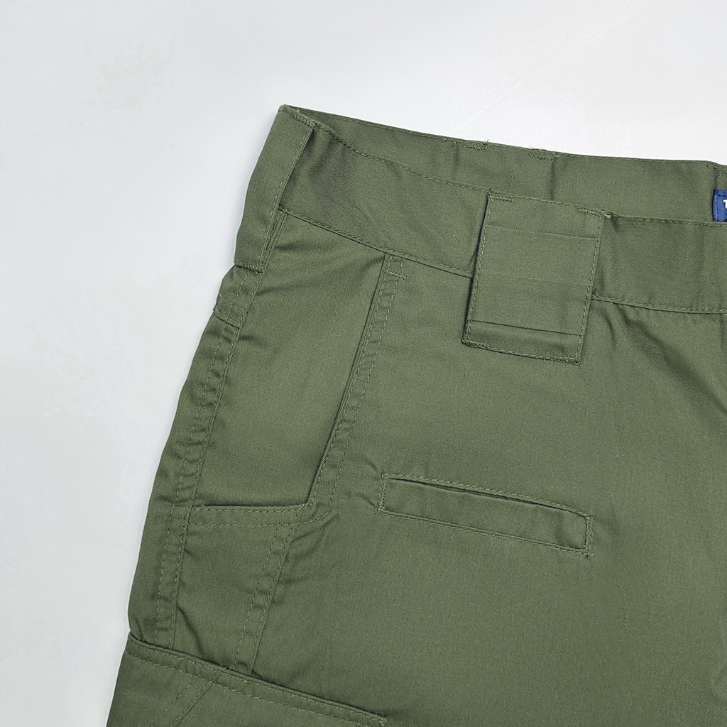 Close-up of the front slant pocket and magazine pocket on the custom olive green tactical trousers.