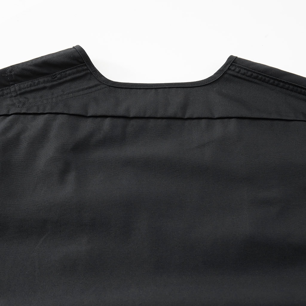 Close-up of the clean back panel and shoulder construction on the custom black multi-pocket tactical vest.