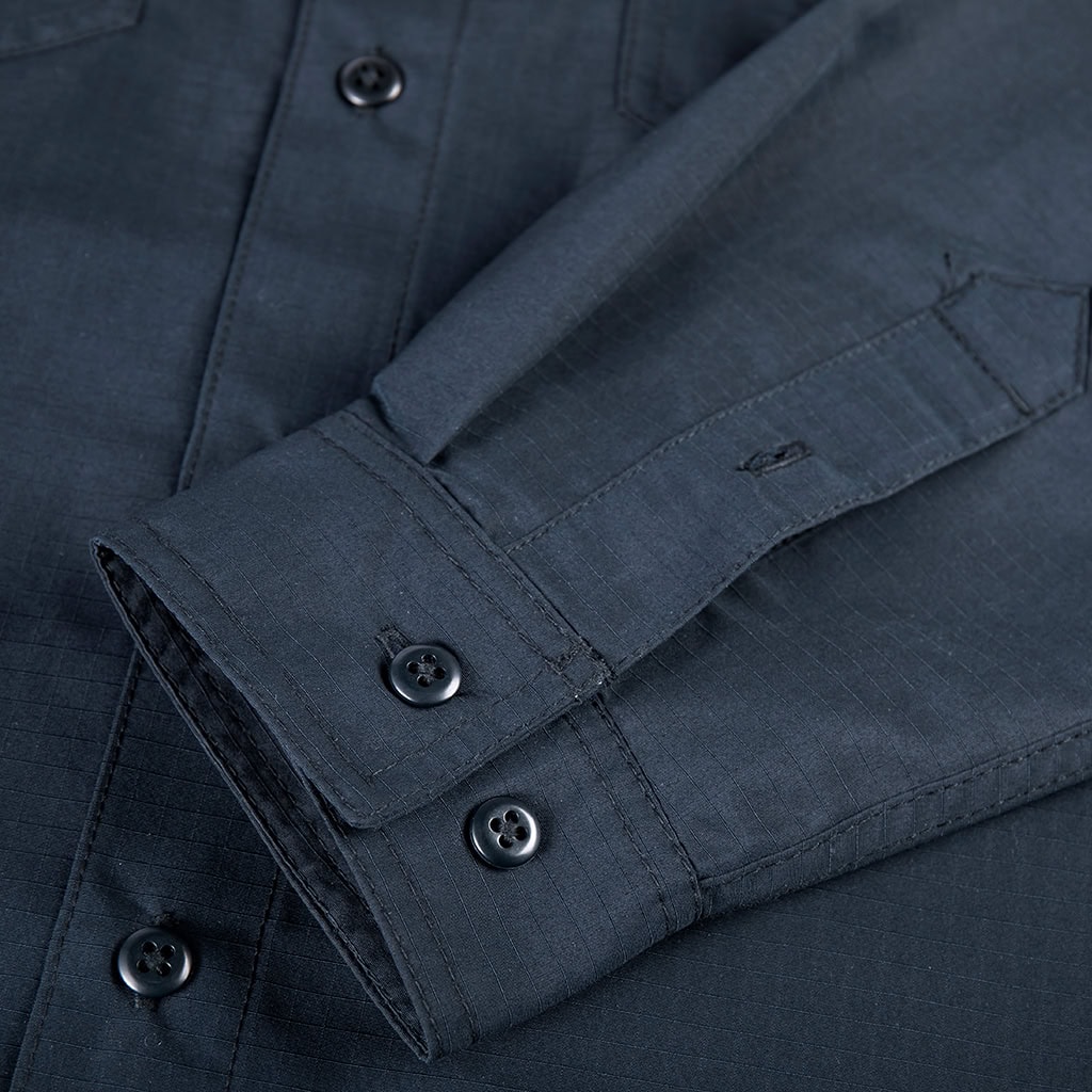 Close-up of the adjustable button cuff on the sleeve of the custom navy blue waterproof work shirt.