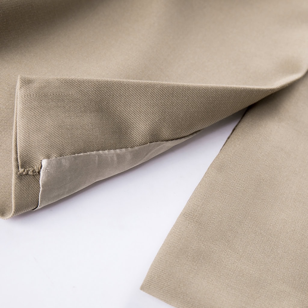 Close-up of the adjustable cuff strap on the sleeve of the custom khaki military officer trench coat.